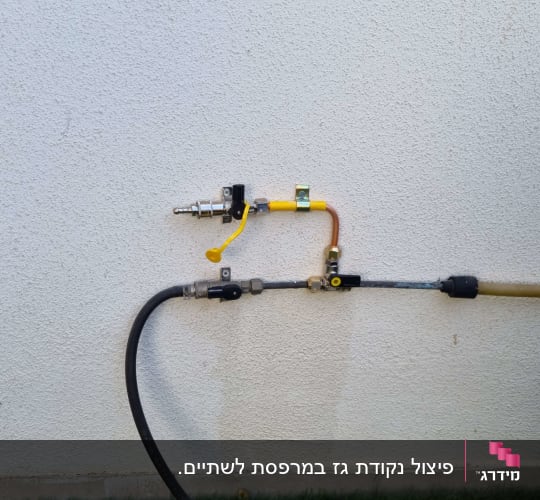 צינור גז עם שסתומים ומחברים על קיר